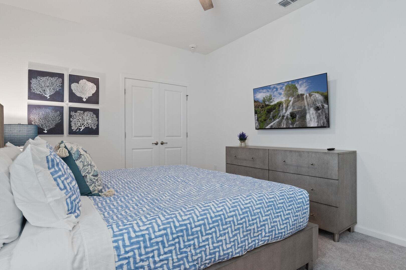 Un dormitorio con cama, cómoda, puerta y decoración en la pared.