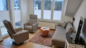 Una sala de estar moderna con un sofá, un sillón y una mesita de centro.
