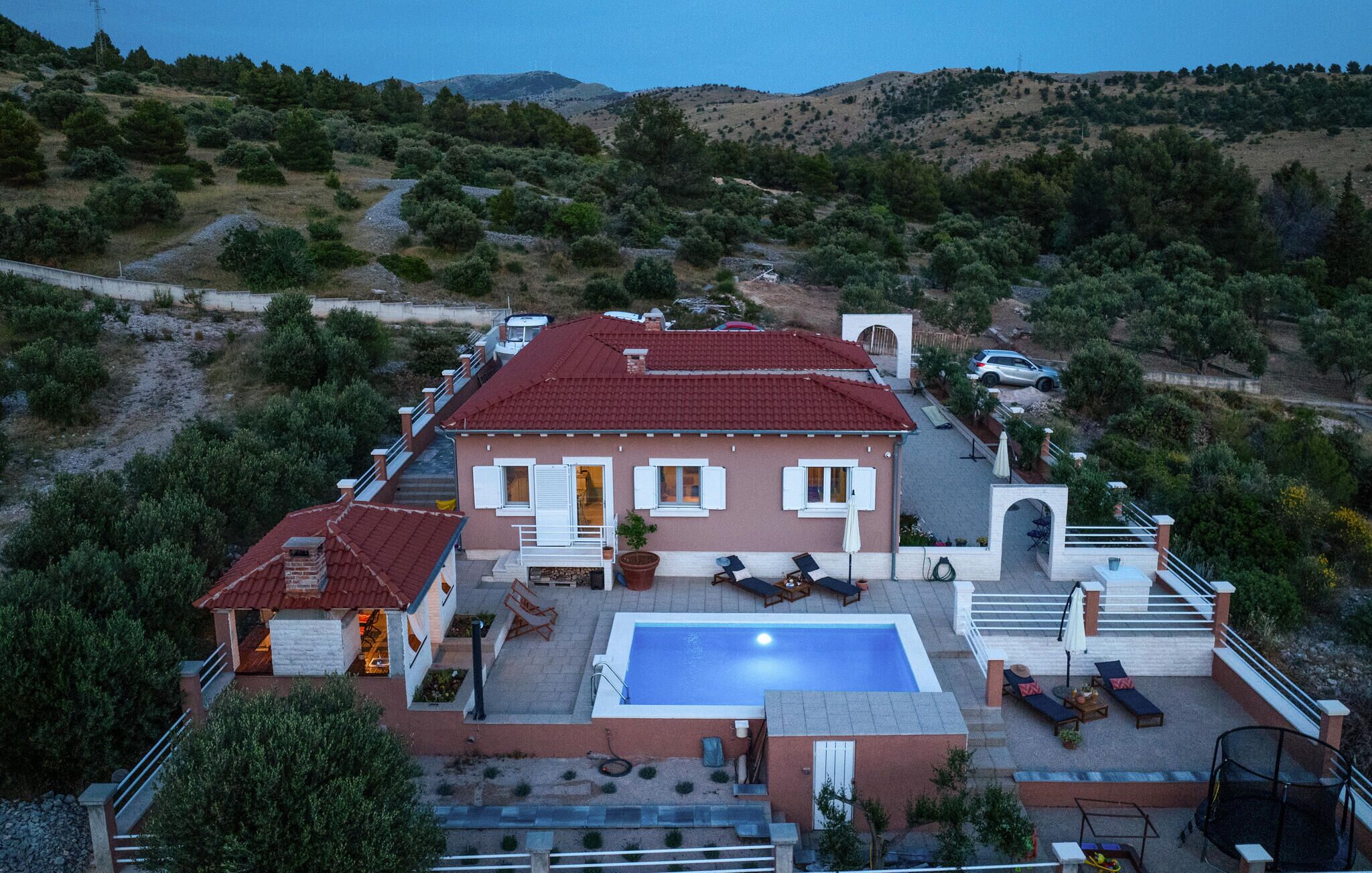 Una casa con piscina, area relax all'aperto e vista sulle colline circostanti.