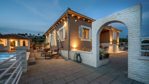 A villa with a swimming pool, outdoor seating, and a stone archway. - Gorgeous home in Zaboric with private swimming pool, can be inside or outside (Zaboric)