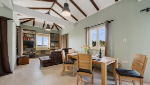 A spacious room with a dining area, wooden furniture, and a large window providing natural light. - Gorgeous home in Zaboric with private swimming pool, can be inside or outside (Zaboric)