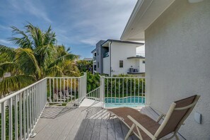 A balcony with a pool, white railing, and a chair. - Bean Point Residence Unit A (Anna Maria)
