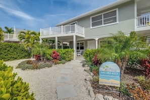 A two-story building with a covered porch and a balcony. - Bean Point Residence Unit B (Anna Maria)