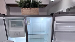 Moderni keittiö, jossa on sisäänrakennettu jääkaappi ja puinen työtaso.