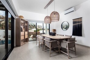 Enjoy meals in this dining area with a large table and six comfortable chairs, illuminated by pendant lights and offering a view of the surrounding area.