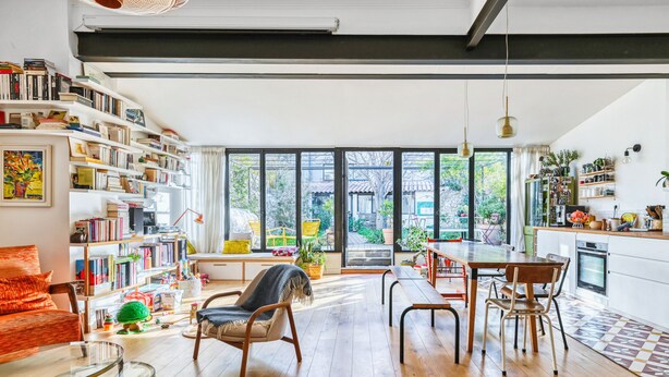 Un amplio espacio habitable con un gran ventanal, una cocina y un comedor.