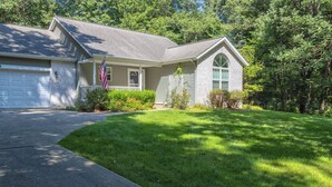 A single-story house with a front garage, a small porch, and a well-maintained lawn. - Bed & Birdie Near Golf Course & Downtown Saugatuck (Saugatuck)