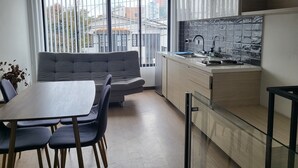 Una cocina moderna con estufa integrada, un fregadero y un ventanal con vistas a un paisaje urbano.