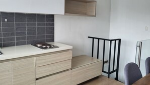 Una cocina moderna con estufa a gas, armarios de madera y salpicadero de baldosas negras.