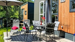 Une terrasse extérieure moderne, dotée d’une table et de chaises, d’une clôture en bois et d’un panneau indiquant le numéro BO 144.