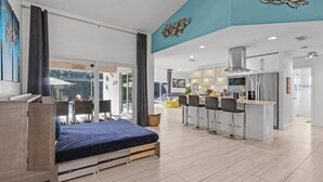 Een moderne hotelkamer met een bed, een zithoek en een keuken.