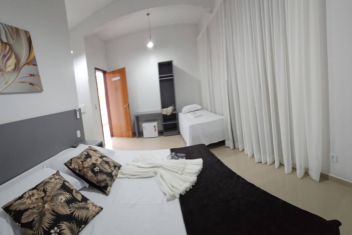 A hotel room with a bed, a desk, a wardrobe, and a bathroom.