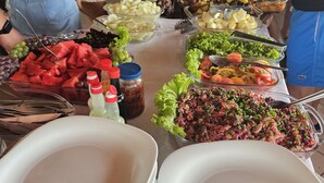 Una mesa de buffet con diversos alimentos y salsas.