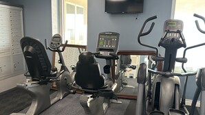 A gym with stationary bikes, an elliptical, and a treadmill. - Beautiful ocean view and beach front close to shopping downtown  (Panama City Beach)