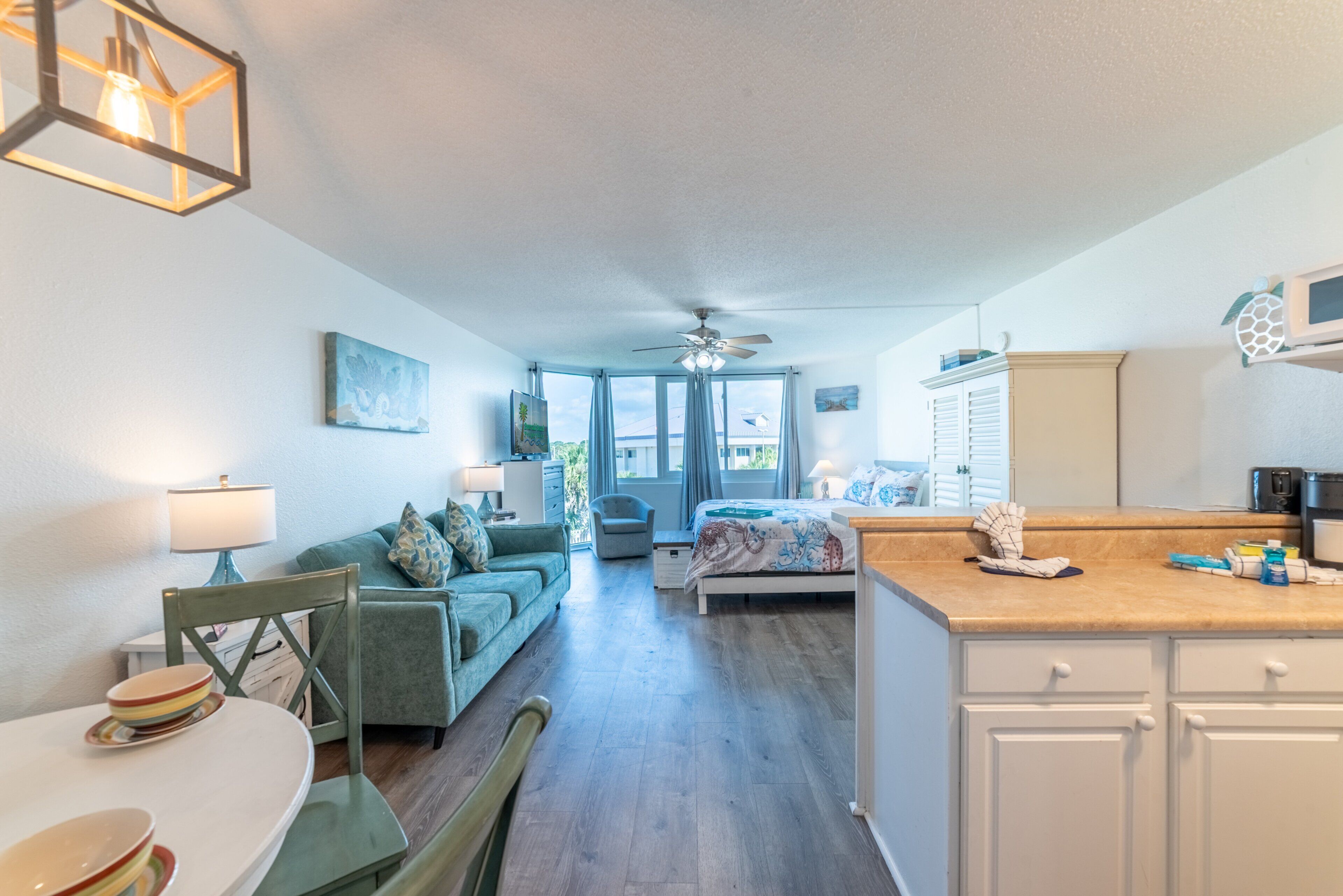 Un espacio habitable compacto con comedor, un dormitorio con vistas y una kitchenette.