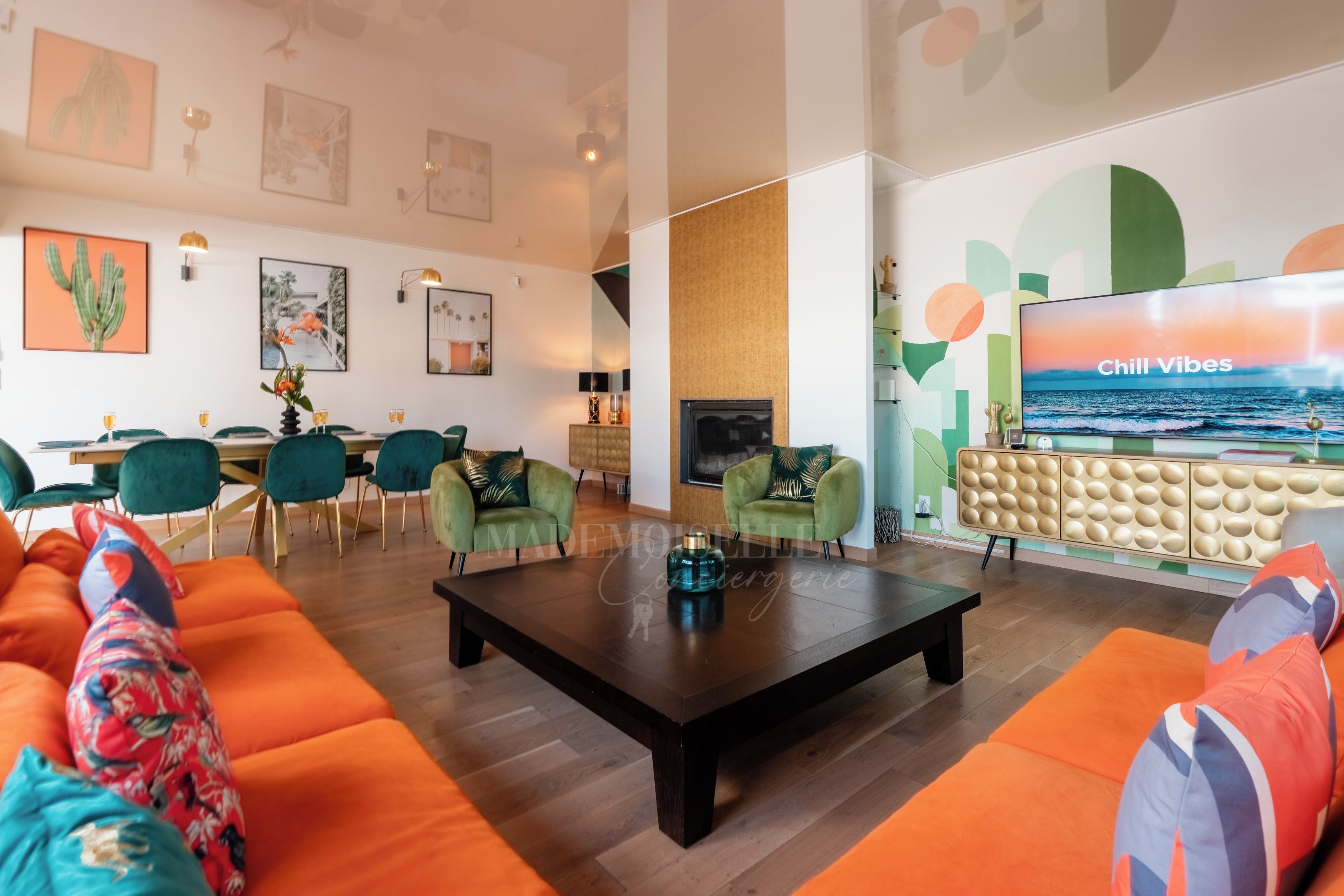 Ein modernes Wohnzimmer mit einer großen Couch, einem Couchtisch und einem Fernseher, der 'Chill Vibes' anzeigt.