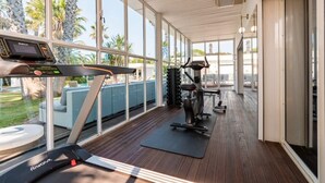 A gym with a treadmill, exercise bike, and weights. - Villa Summer Wind - Palm Beach Agathois (Agde)