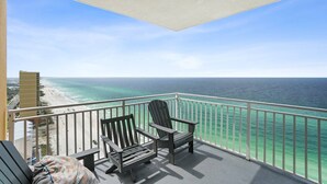A balcony with a view of the ocean and beach.