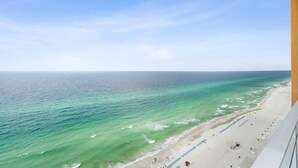 A beach view from a balcony with a clear sky.