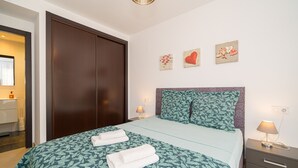 A hotel room with a bed, a nightstand, a lamp, and a wall with three decorative items. - Apartamento Mariphils (Linnea Sol) (Orihuela Costa)