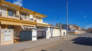 Un immeuble d’habitation doté d’une entrée sécurisée, d’un balcon et surplombant un ciel d’un bleu éclatant.
