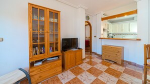 Une pièce avec un meuble en bois, une télévision et un miroir.