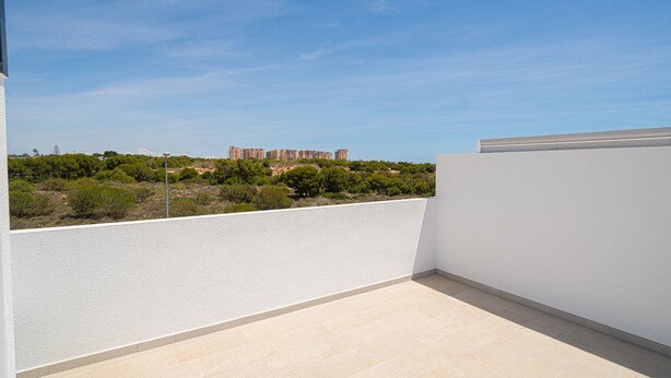 A rooftop terrace with a view of distant buildings and greenery. - Apartamento Iseo (Mil Palmeras) (Pilar de la Horadada)