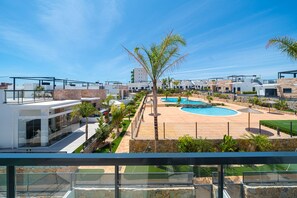 Un complexe hôtelier moderne doté d’une piscine, de plusieurs bâtiments et surplombant un ciel d’un bleu éclatant.