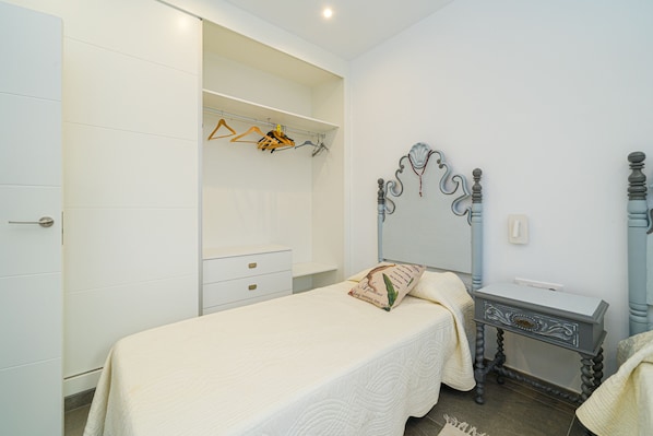 A bedroom with a bed, a dresser, a wardrobe, and a mirror.