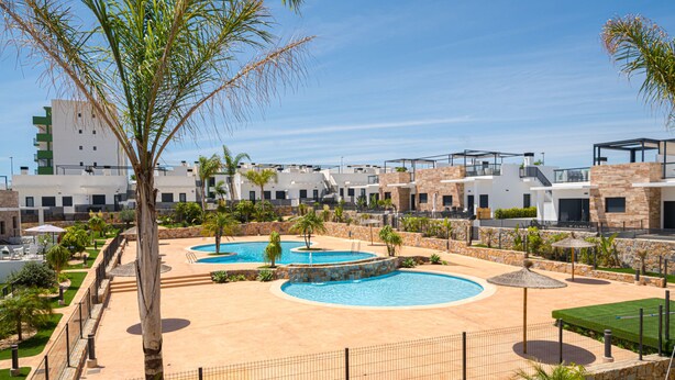 Un complexe hôtelier doté de plusieurs piscines, de palmiers et de bâtiments modernes.