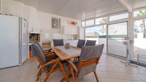 A spacious kitchen with a dining area, large windows, and a view of the outside.