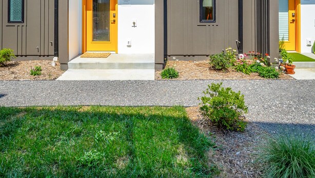 A modern multi-story building with two visible entrances, each marked with a number. - Basecamp - a PMI Scenic City Vacation Rental (Chattanooga)