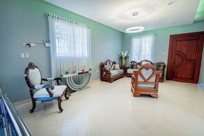 Una sala de estar amplia con un conjunto de sofá, una mesa de centro y un sillón decorativo.