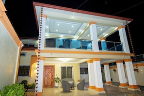 A two-story building with a balcony, large windows, and a door. - Villa Mirella , Santiago Poolside retreat (Santiago de los Caballeros)
