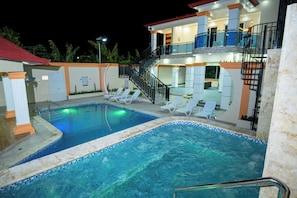 A swimming pool area with lounge chairs and a staircase leading to a second-floor balcony. - Villa Mirella , Santiago Poolside retreat (Santiago de los Caballeros)