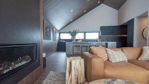Una sala moderna con chimenea, un sofá de cuero y una mesa de centro de mármol.