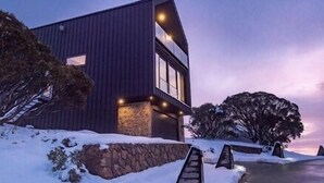 Un edificio moderno con base de piedra y fachada de metal.