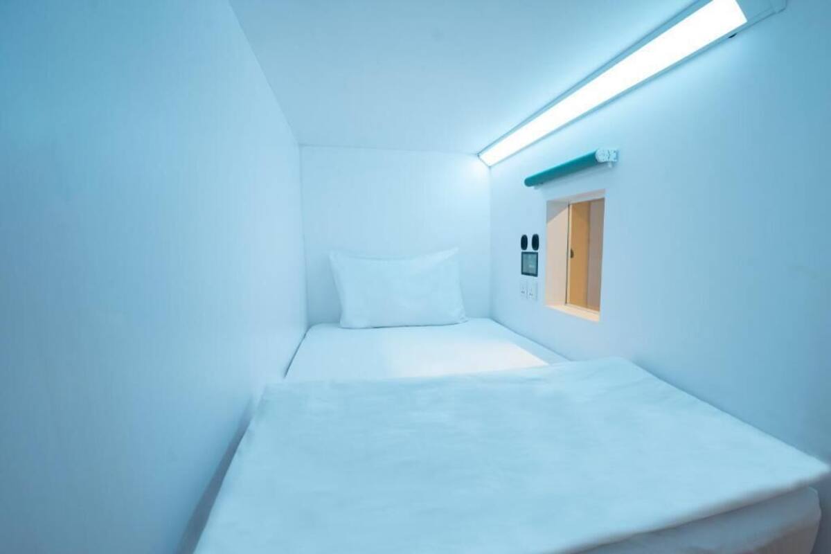 A small, single-bed room with a slanted ceiling and a skylight.
