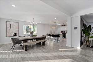 Una cocina moderna con armarios blancos, una isla central e iluminación colgante.