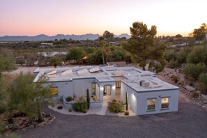 Una casa moderna con techo plano, varias habitaciones y vistas al paisaje desértico circundante.