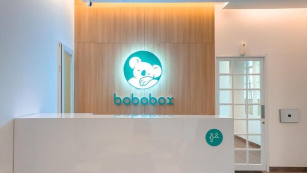 Una recepción con un panel de madera y un logotipo que muestra un koala.