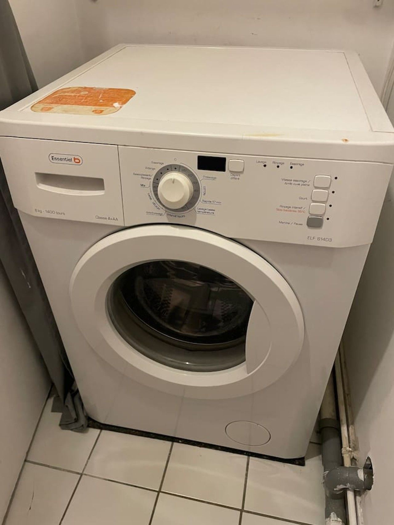 Une machine à laver à chargement frontal, dotée d’un panneau de commande, d’un compartiment à lessive et d’une étiquette indiquant qu’il s’agit d’un appareil de classe A+.