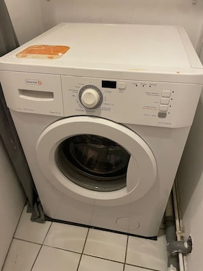 Une machine à laver à chargement frontal, dotée d’un panneau de commande, d’un compartiment à lessive et d’une étiquette indiquant qu’il s’agit d’un appareil de classe A+.