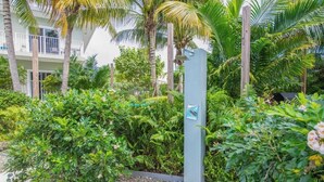 Un jardín exuberante con follaje denso y un edificio moderno con balcones.