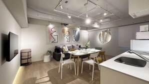 Et moderne køkken med spiseplads, med en hvid bordplade, vask og spisebord med stole.