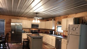 A compact kitchen with wooden cabinets, stainless steel appliances, and a central island.