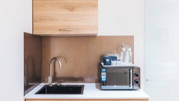 A modern kitchen with a built-in microwave, a sink, and wooden cabinetry.