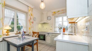 Eine Küche mit Esstisch, Backofen und Spüle.