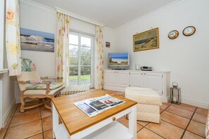 Un salon chaleureux avec une table en bois, un canapé et un téléviseur.