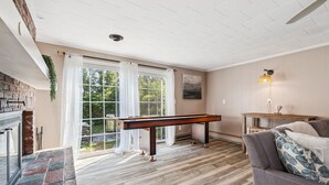 A room with a pool table, a fireplace, and a view of the outdoors. - Steps to Beach | Backyard | Shuffle Board (Hampton)